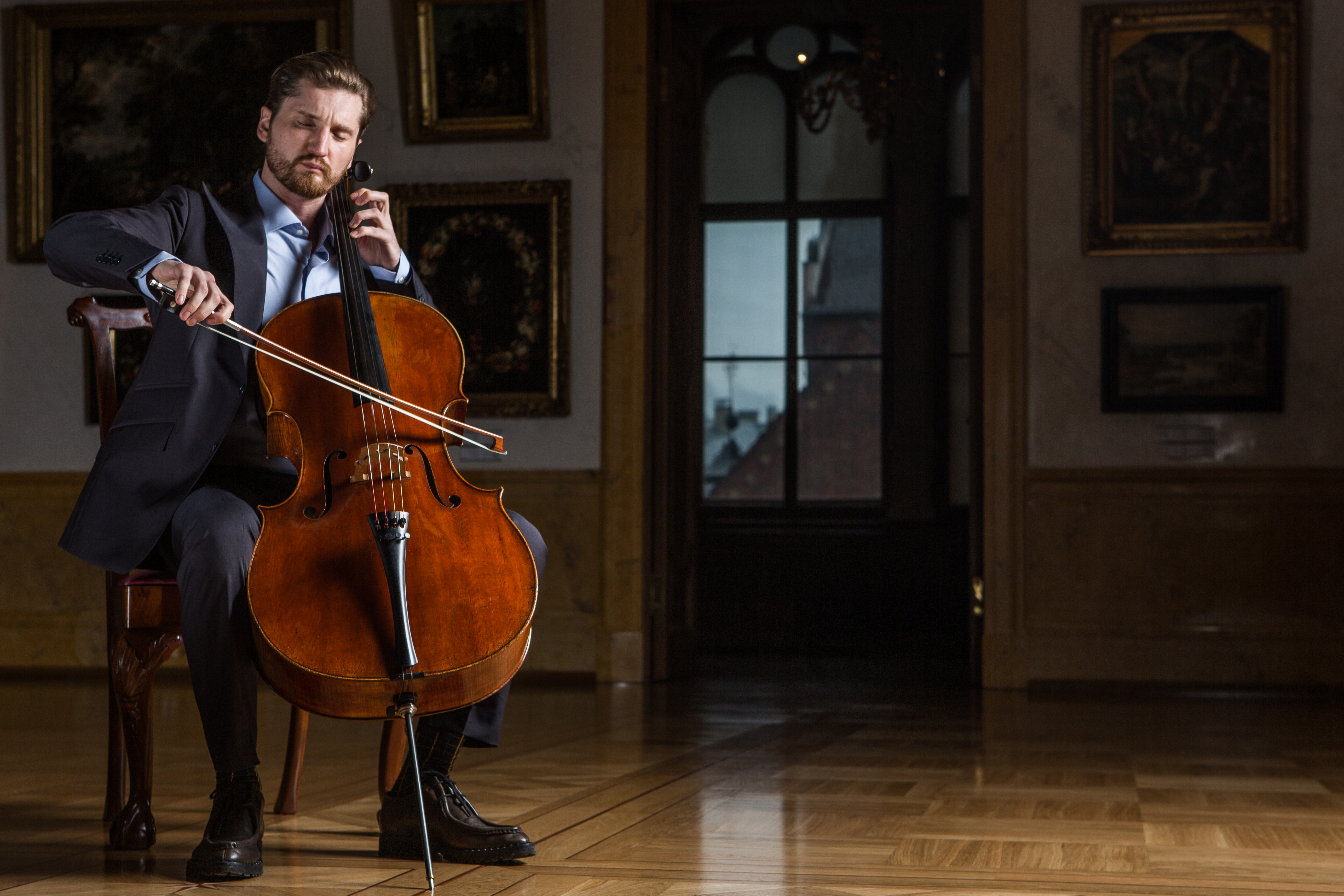 Max Beitan with the Stradivari “Archinto” 1689 cello in a concert hall.
