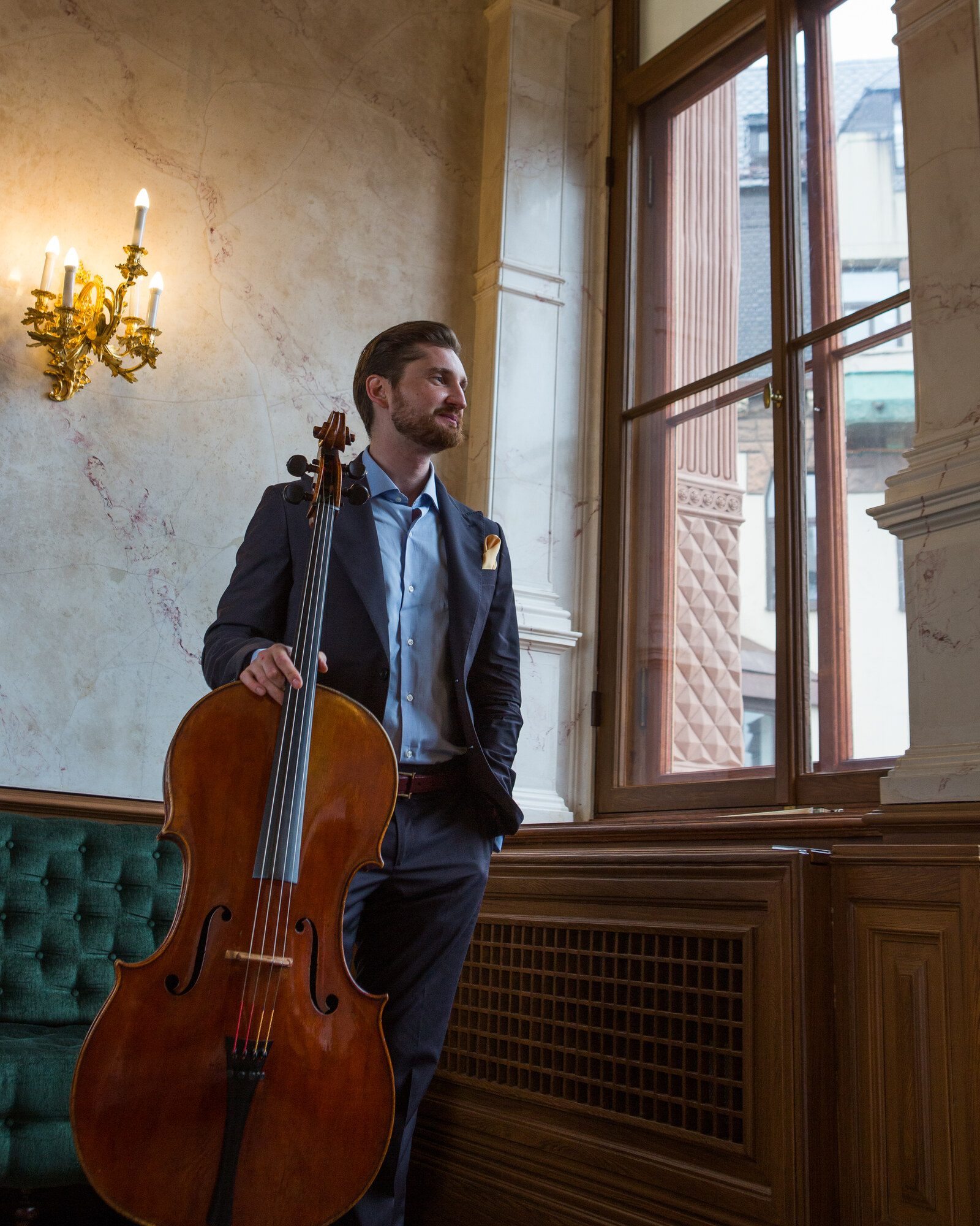 Max Beitan with the Stradivari “Archinto” 1689 cello at a palace window.